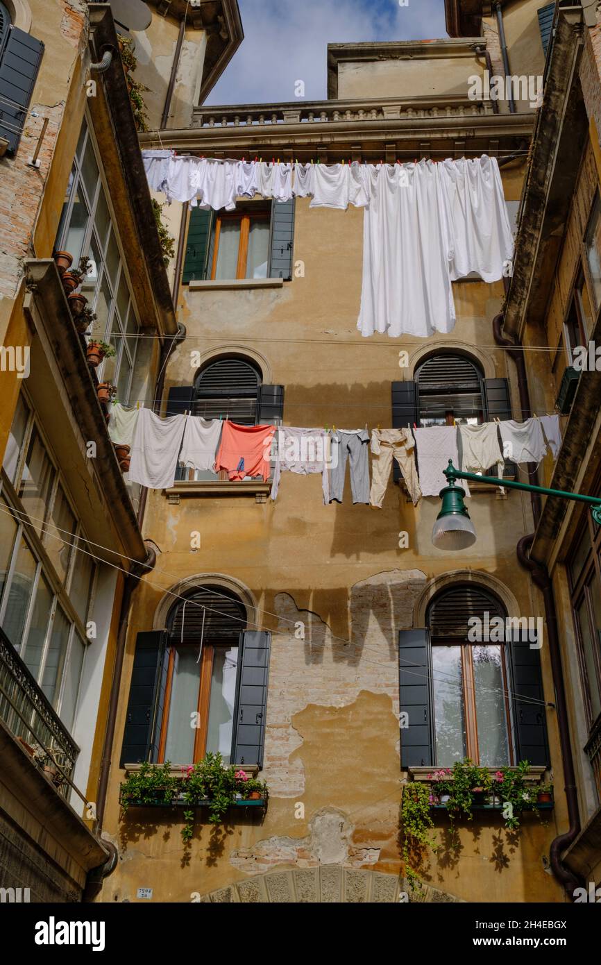 Clothes hanging from building on washing line in Venice Stock Photo
