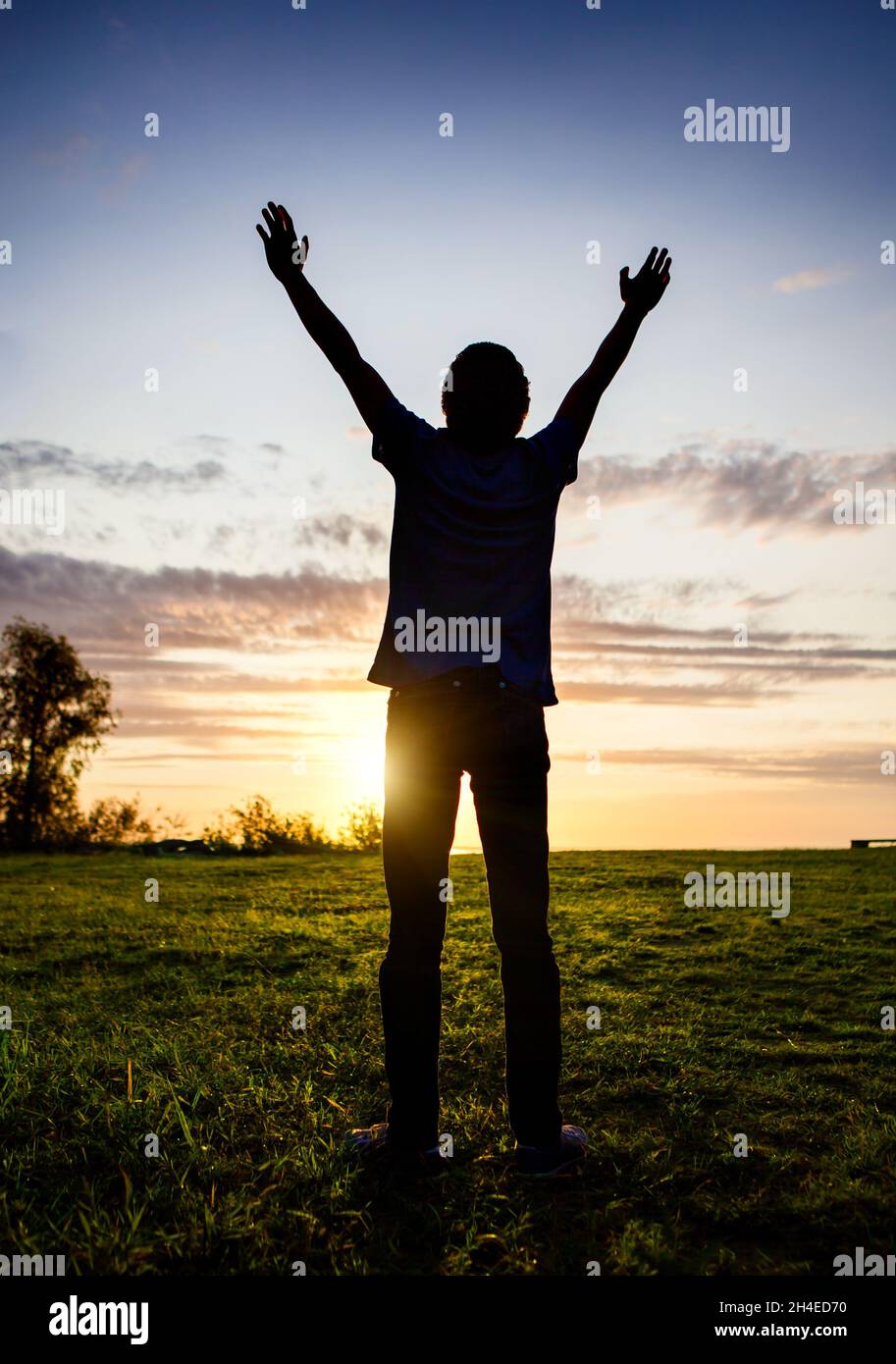 Happy Man Silhouette with Hands Up on the Sunset Background Stock Photo ...