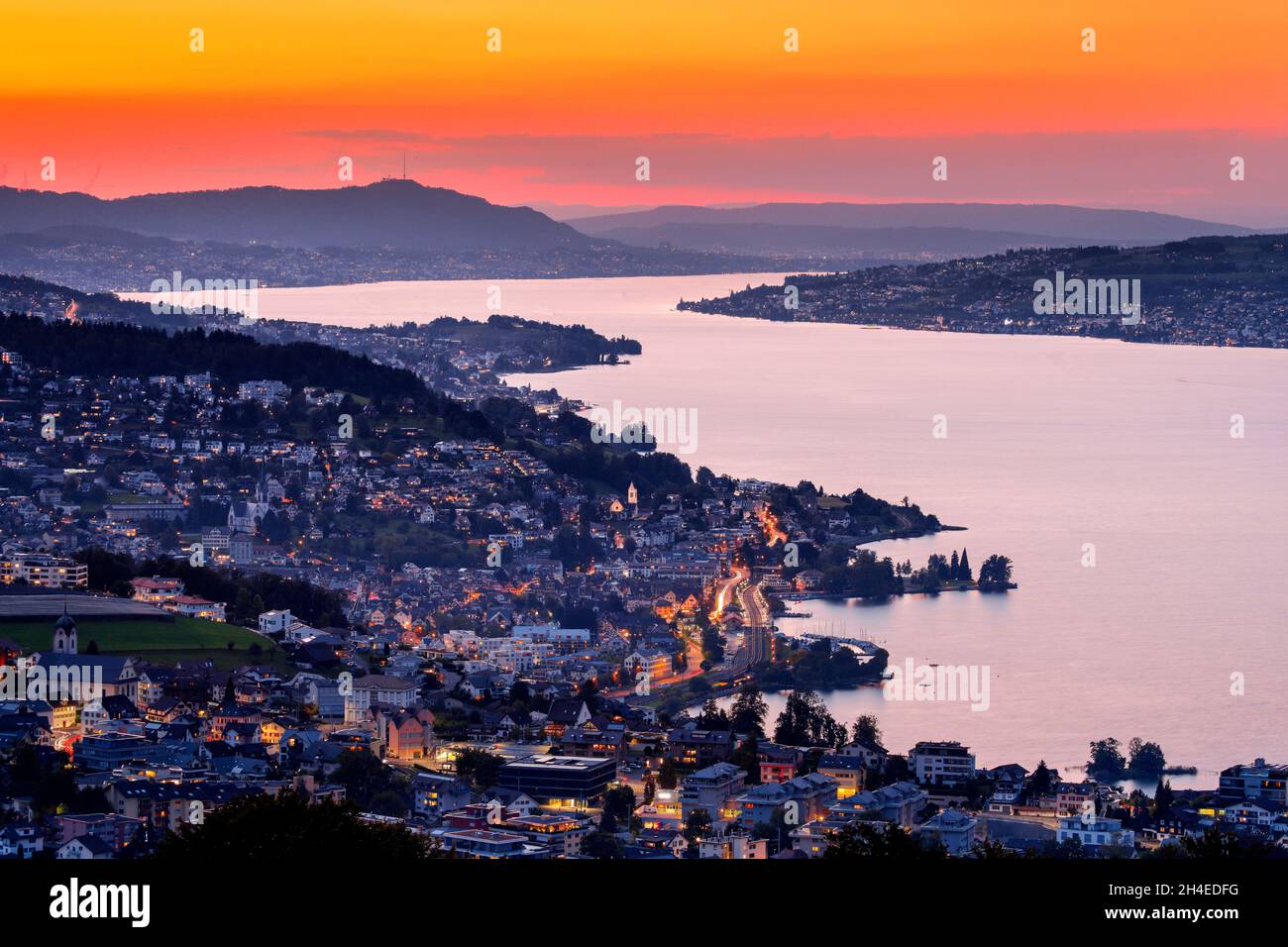 Blick bei Abenddämmerung von Feusisberg über den Zürichsee nach Zürich, mit den beleuchteten Ortschaften Wollerau, Richterswil, Wädenswil und Meilen u Stock Photo