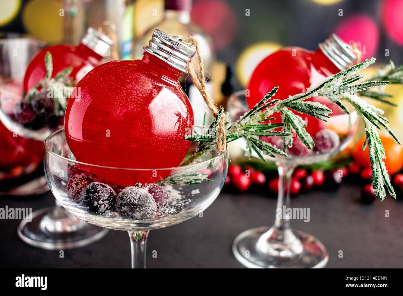 Holiday Gin and Tonic Cocktail Served Inside a Christmas Ornament: A cranberry and gin cocktail served in a coupe glass Stock Photo