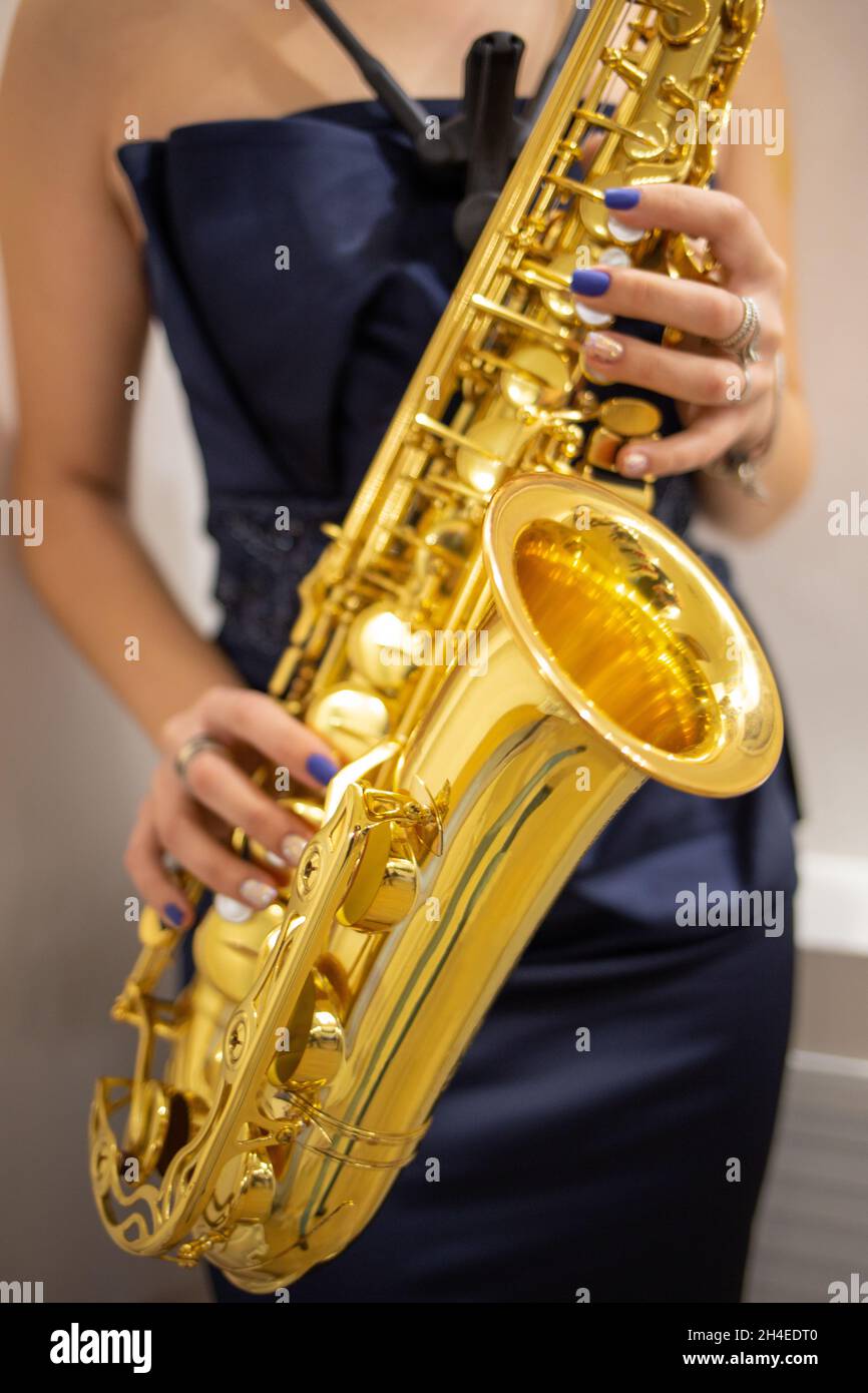 Young woman jazz musician playing the saxophone, closeup image Stock Photo