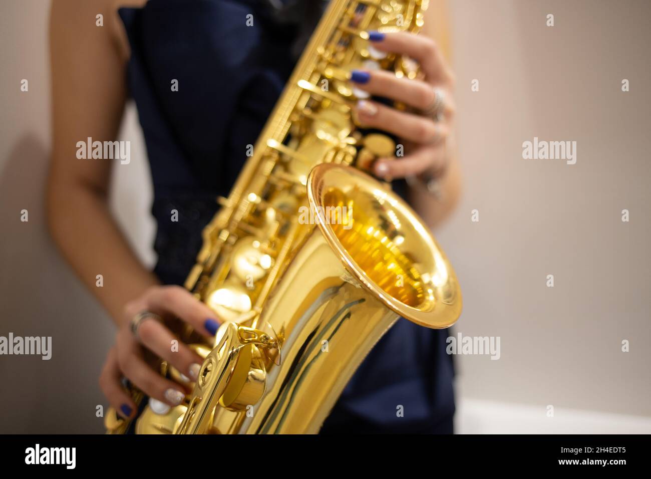 Young woman jazz musician playing the saxophone, closeup image Stock Photo
