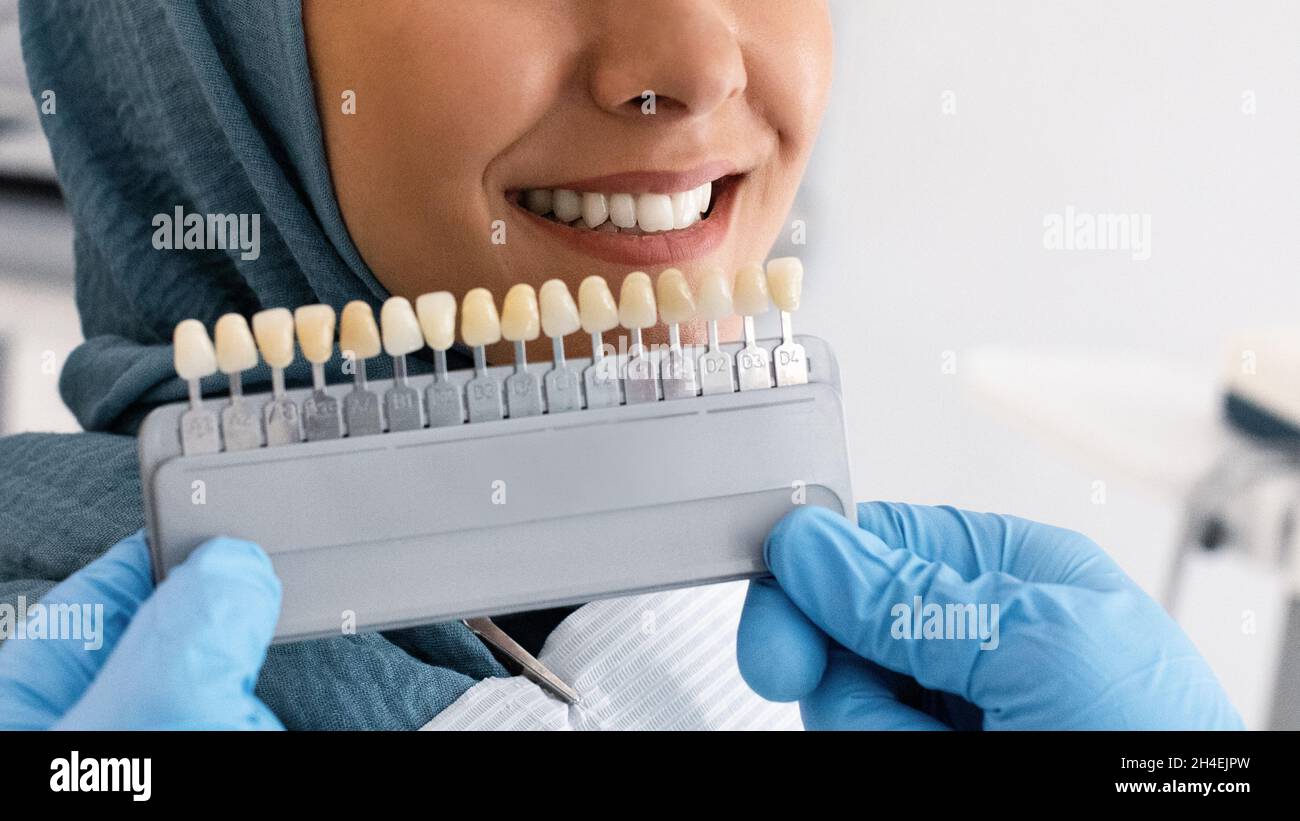 Dentist Holding Teeth Shade Chart Choosing Right Enamel Color For Muslim Patient Stock Photo