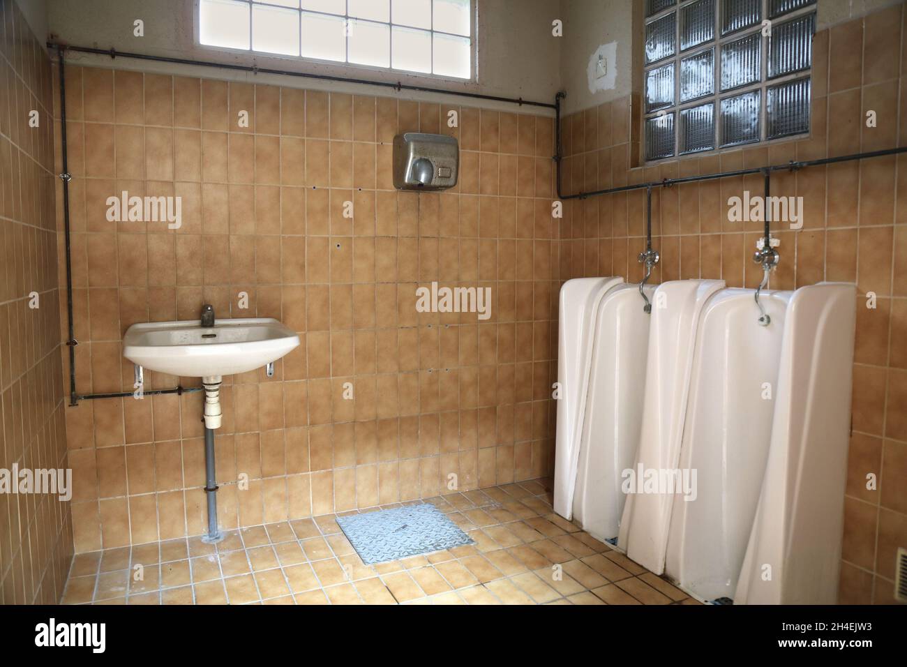 Public restroom sink and urinals in France. Public toilet typical for