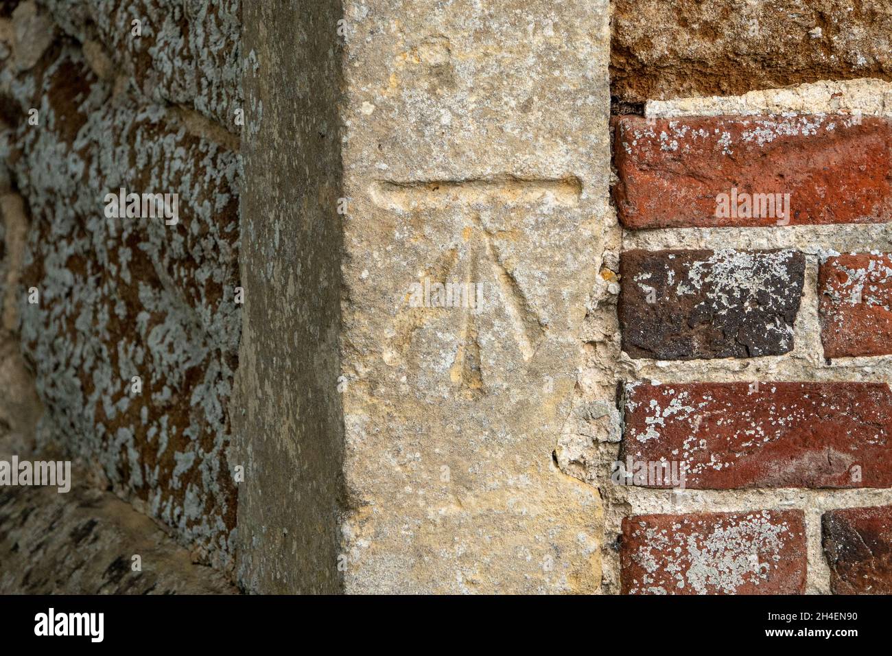 A surveyors benchmark on the corner stone of the Church of St John the Baptist Wantisden, Suffolk, UK Stock Photo