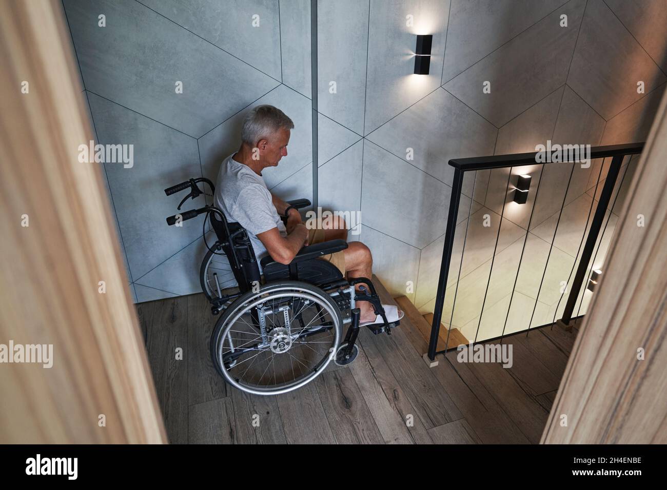 Male wheelchair user having problems with climbing down stairs Stock