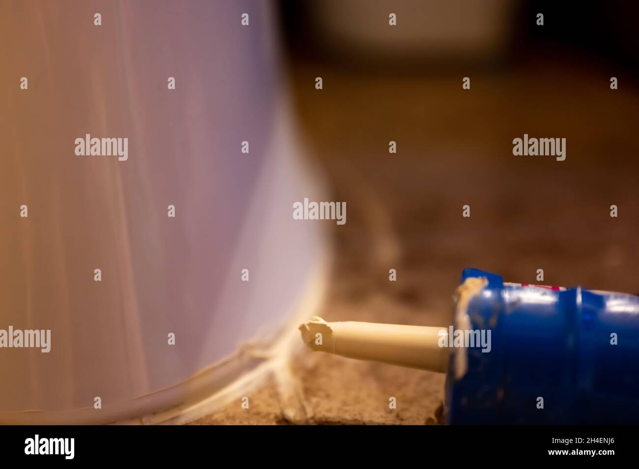 Selective focus on silicone caulking ready to be applied around the