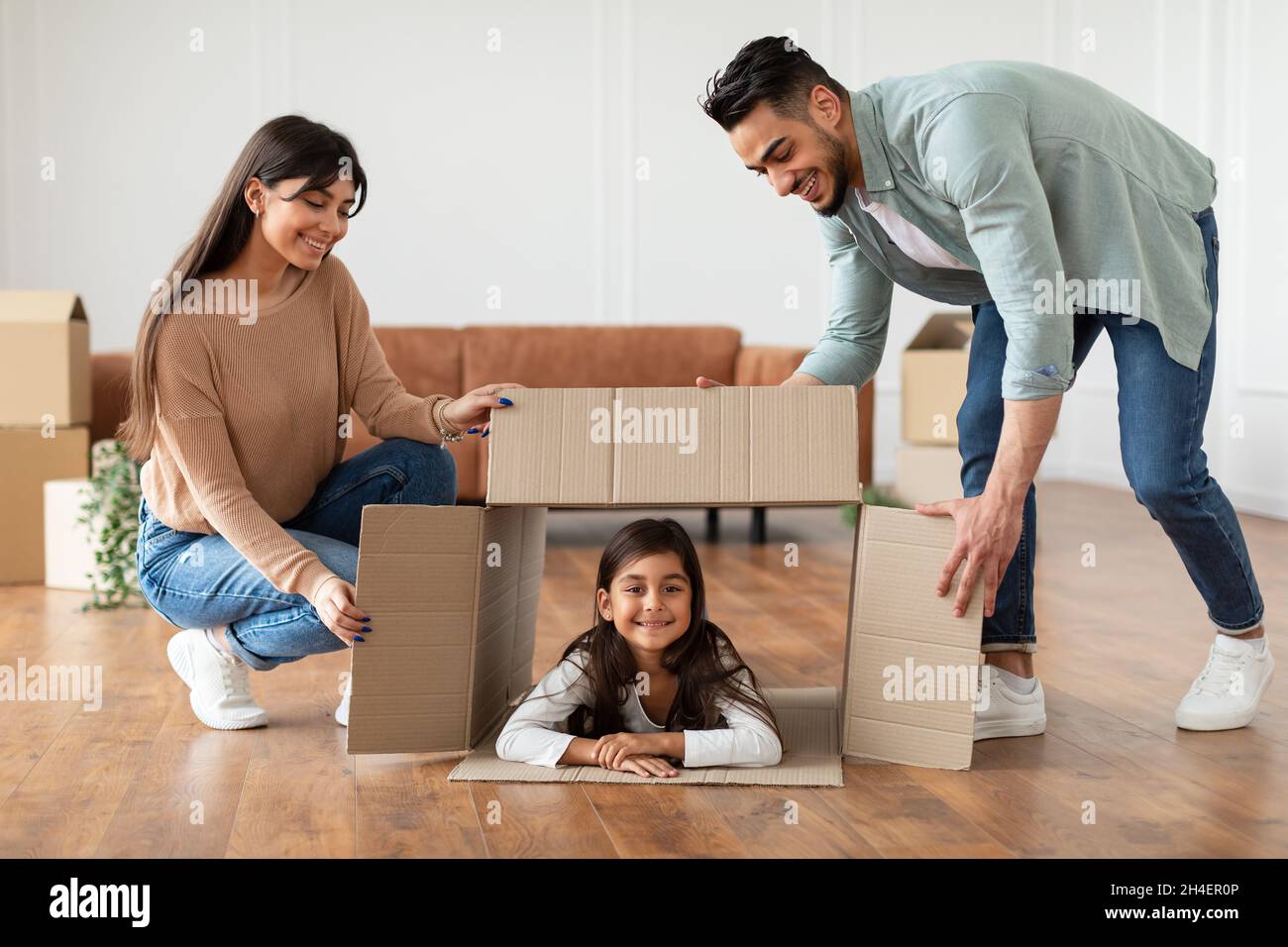 Happy loving young family playing during relocation together Stock Photo