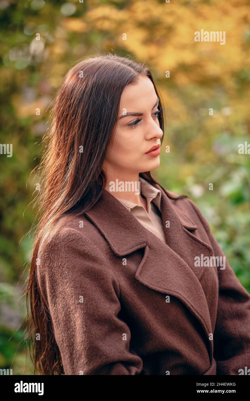Young beautiful woman in brown coat in the park in autumn Stock Photo ...