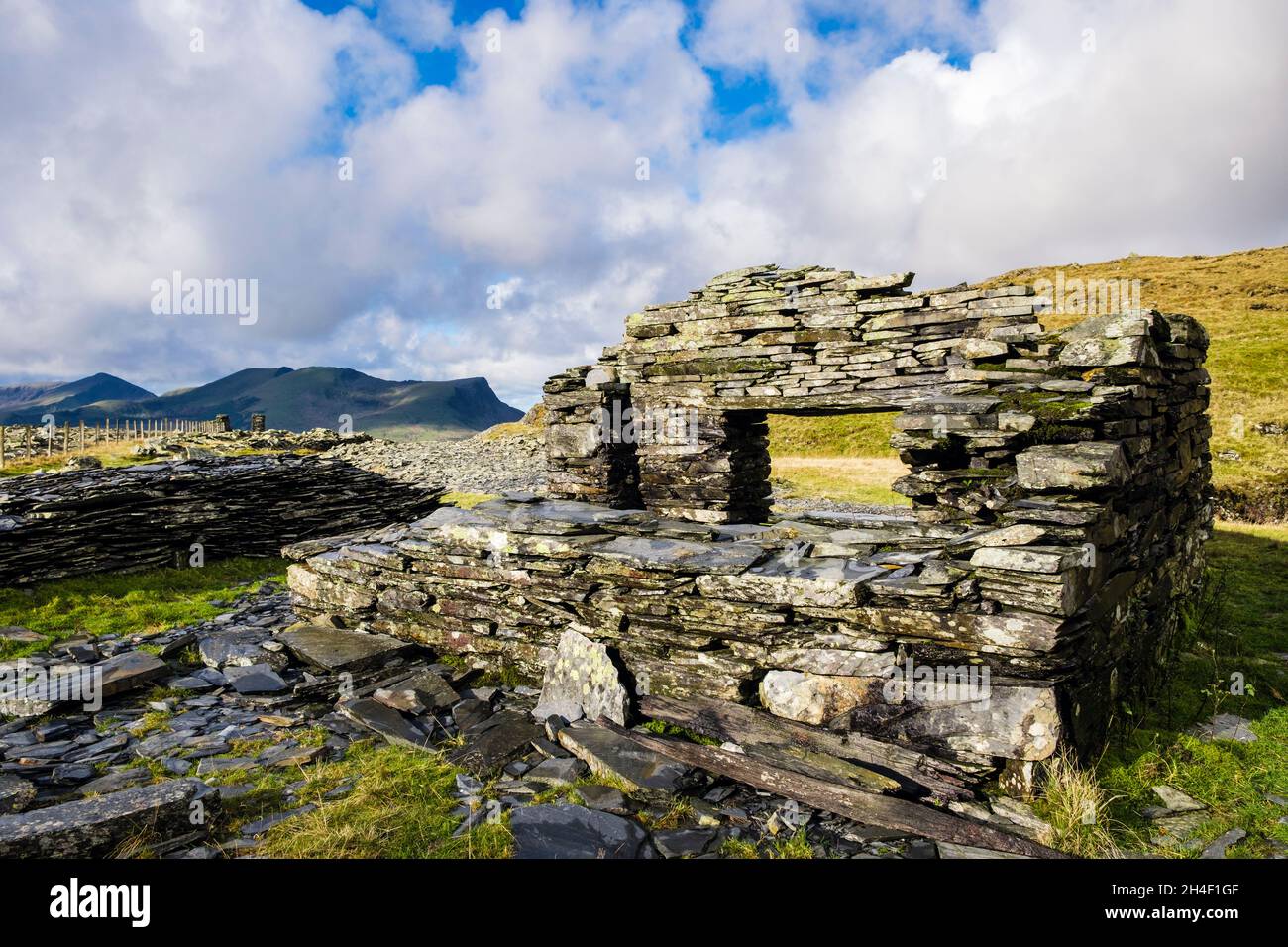 Derelict old slate quarry building on Miners Track from Rhyd Ddu with Nantlle Ridge in distance in Snowdonia National Park. Gwynedd, north Wales, UK, Stock Photo