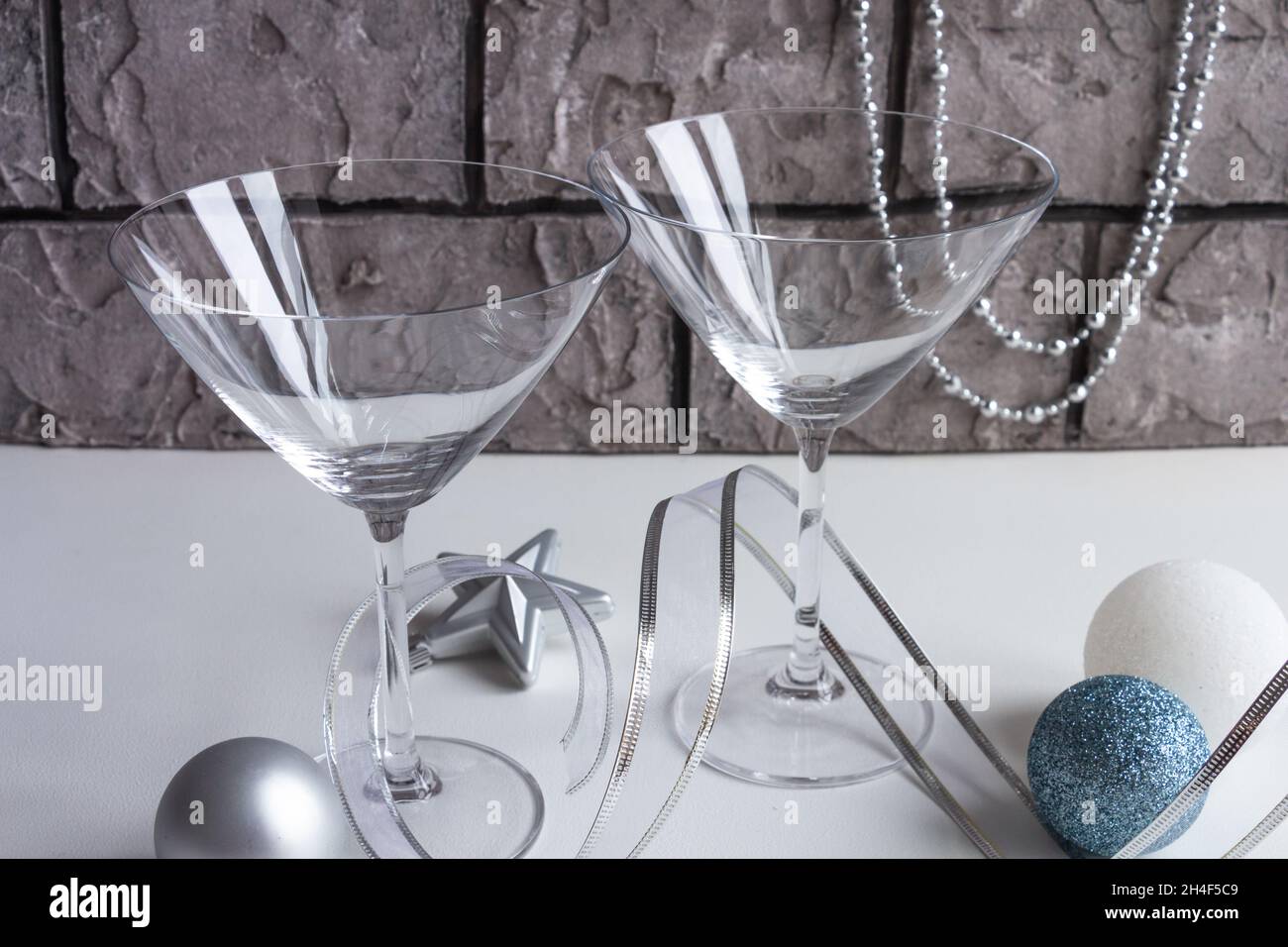 https://c8.alamy.com/comp/2H4F5C9/empty-martini-glass-beautiful-new-year-composition-christmas-tree-decorations-and-silver-ribbon-composition-colors-silver-gold-blue-high-quali-2H4F5C9.jpg