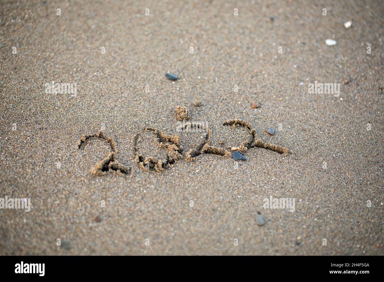 2022 year drawing on the sand at the beach. Stock Photo