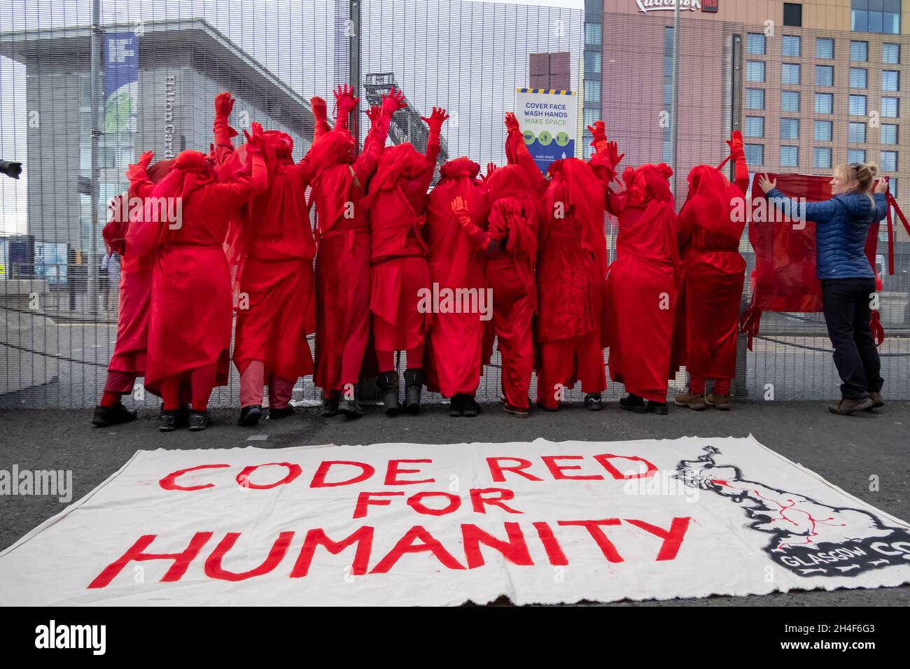 Glasgow, Scotland, UK. 2nd November 2021: Extinction Rebellion's Red Rebel Brigade perform outside the Scottish Event Campus (SEC) on day three of the UN climate change conference COP26. Credit: Skully/Alamy Live News Stock Photo
