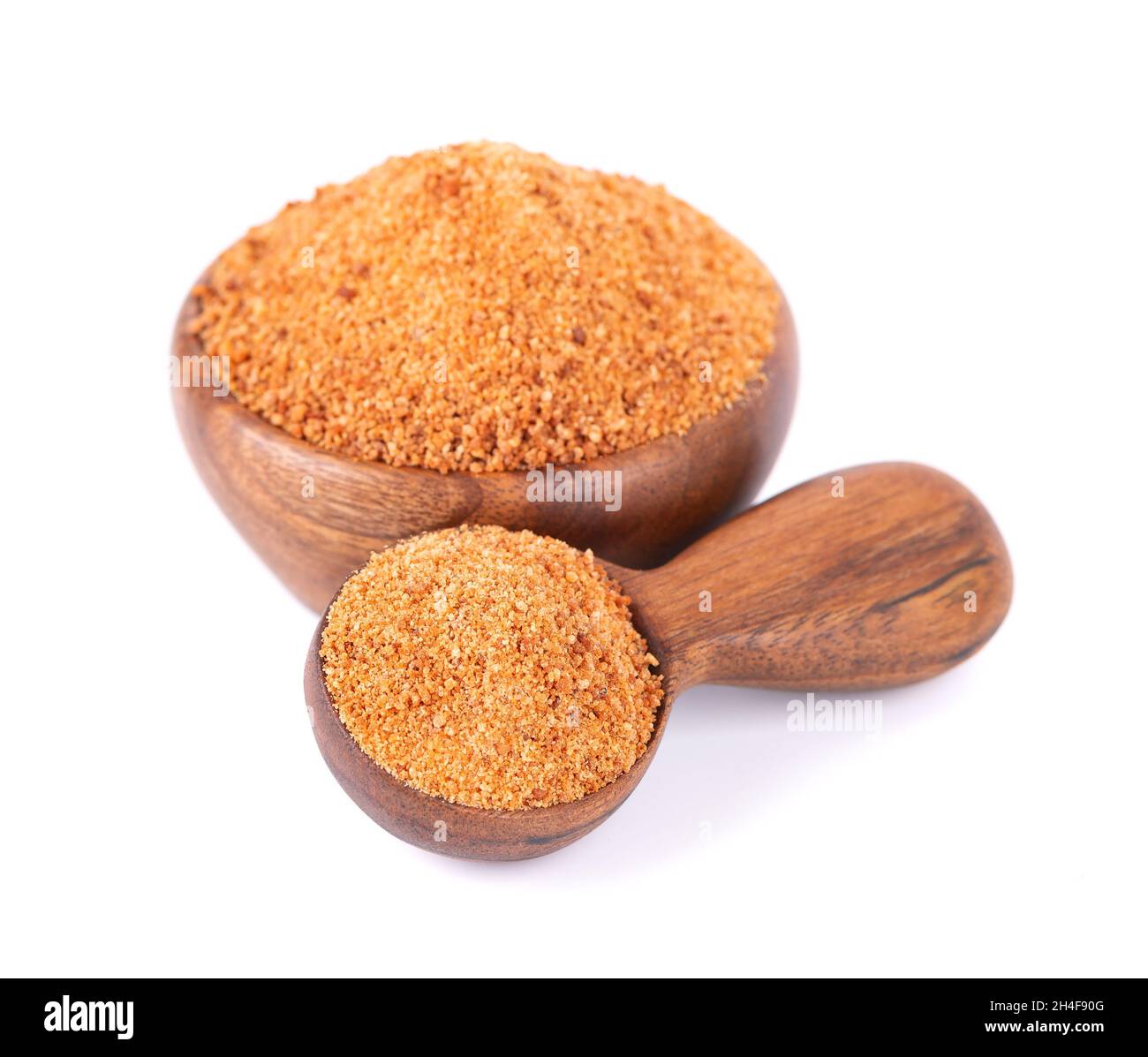 Coconut sugar isolated on white background. Brown unrefined coconut palm sugar in wooden bowl and spoon. Stock Photo