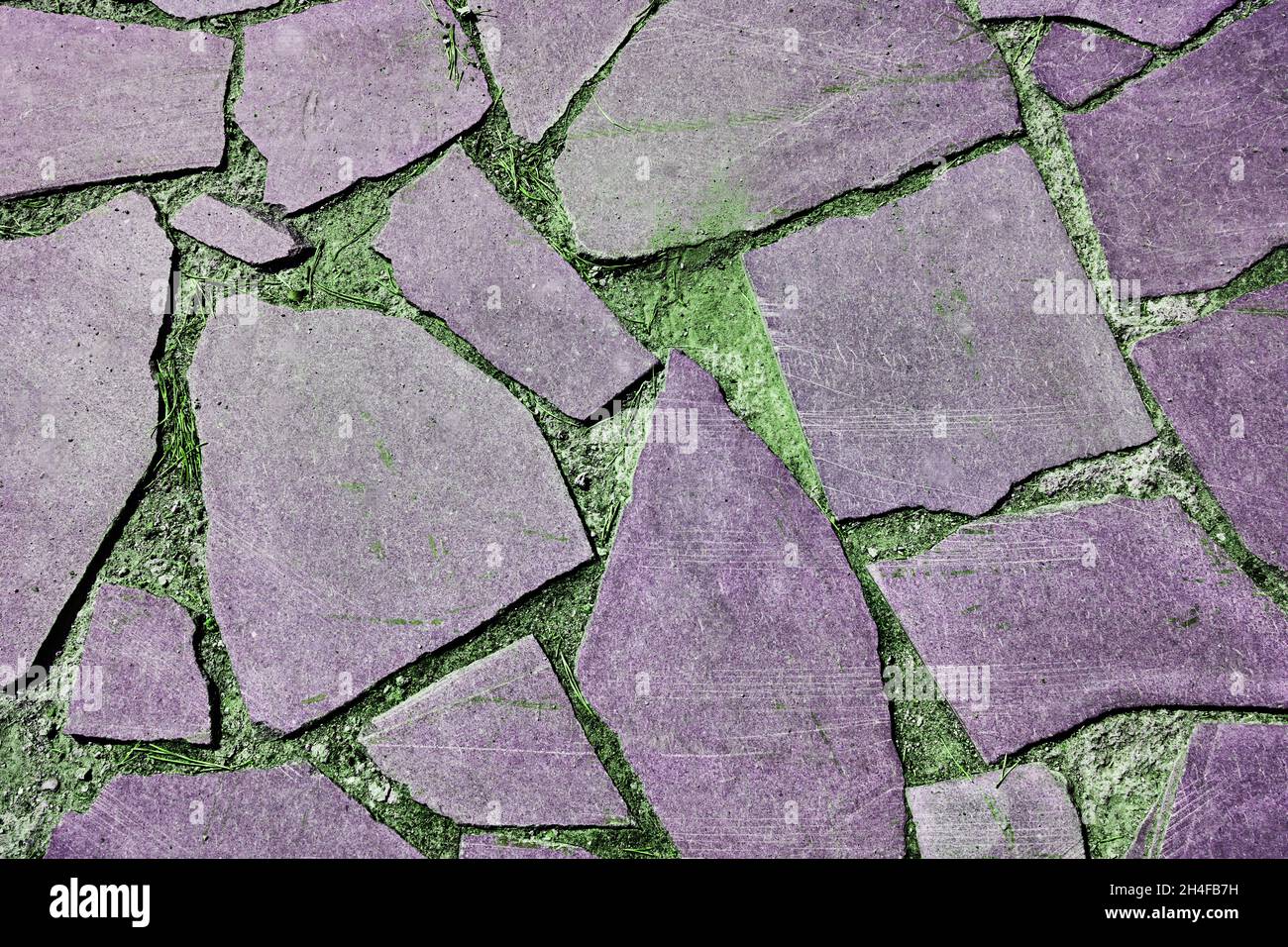 Gray old stone pavement on a background of green grass. Seamless Texture. Texture of a stone road. High quality photo Stock Photo