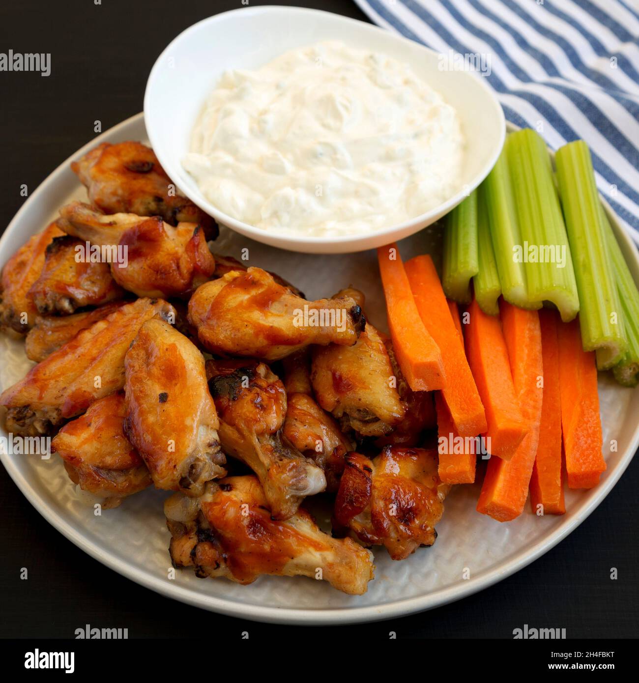 Homemade Chicken Wings with Blue Cheese Dip on a black background, side