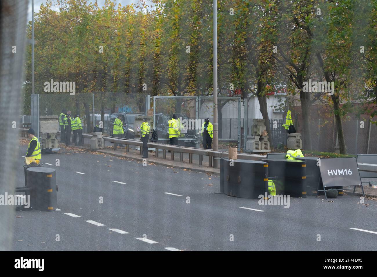 Glasgow, Scotland, UK. 2nd Nov, 2021. Seen through metal security fencing the A814 Clydeside Expressway which runs alongside the SEC campus. The road is being used to escort world leaders who are staying outside Glasgow to and from the venue. Pictured: cars outside security gates waiting to enter after security checks Credit: Kay Roxby/Alamy Live News Stock Photo