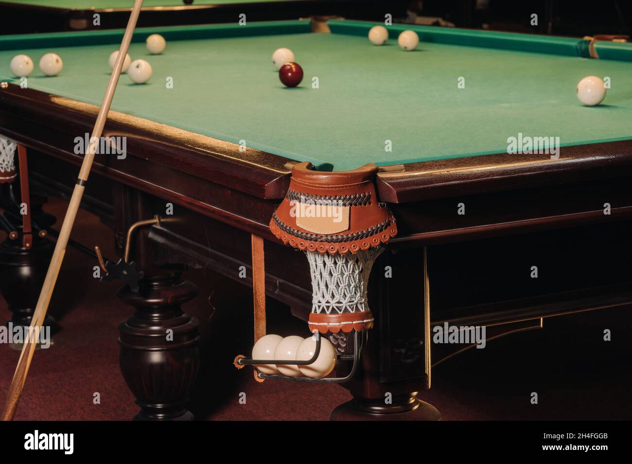 A pool table with balls that have already been played in the pool club.Playing billiards. Stock Photo