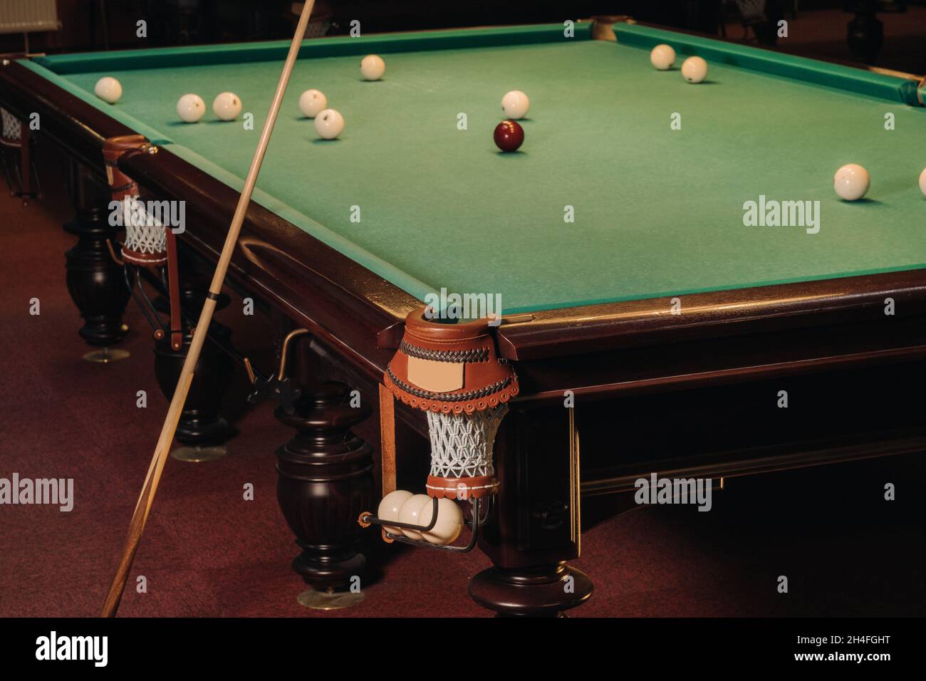 A pool table with balls that have already been played in the pool club.Playing billiards. Stock Photo