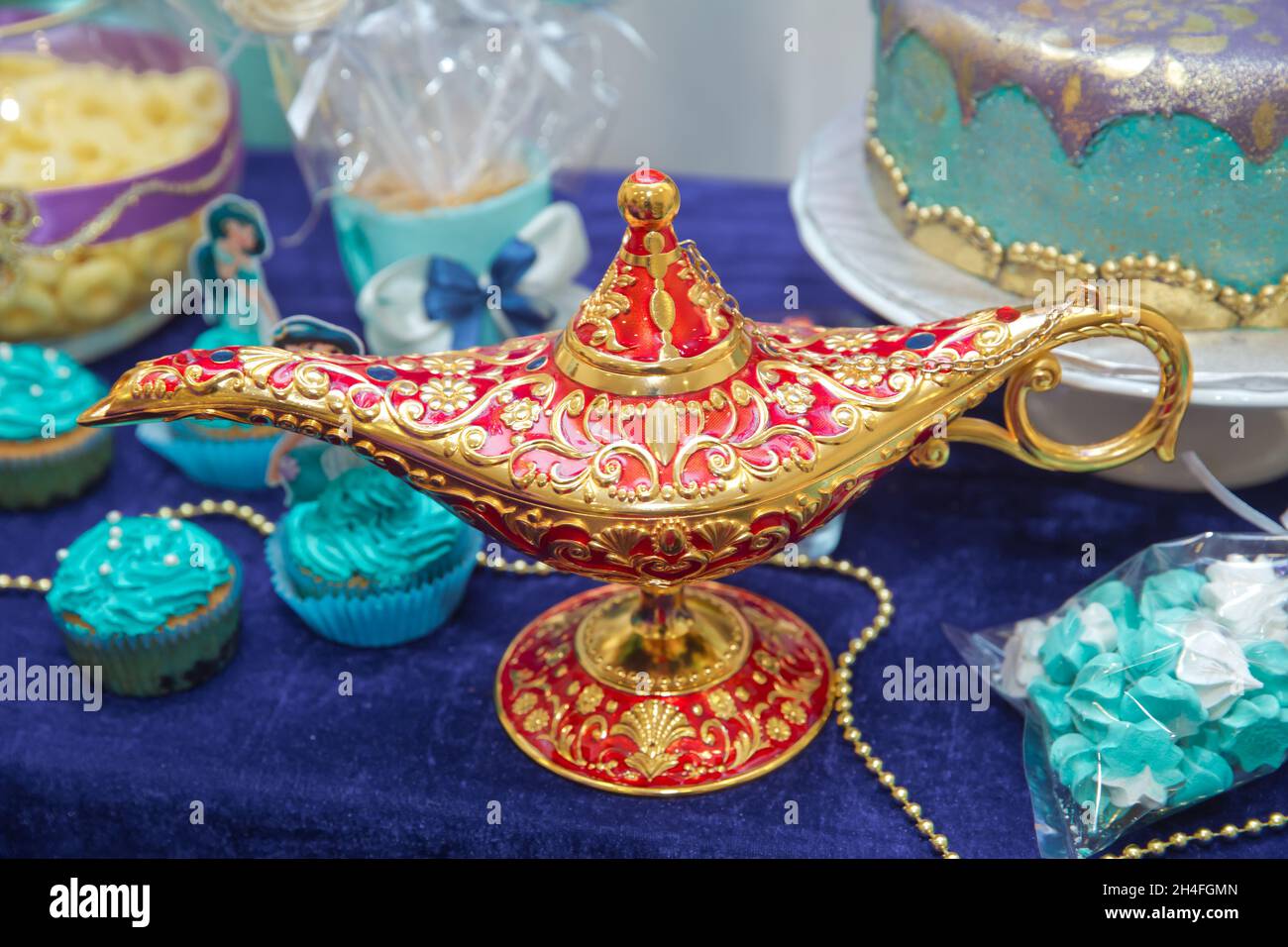 Aladdin lamp of wishes on table . Aladdin's magic genie lamp in red and