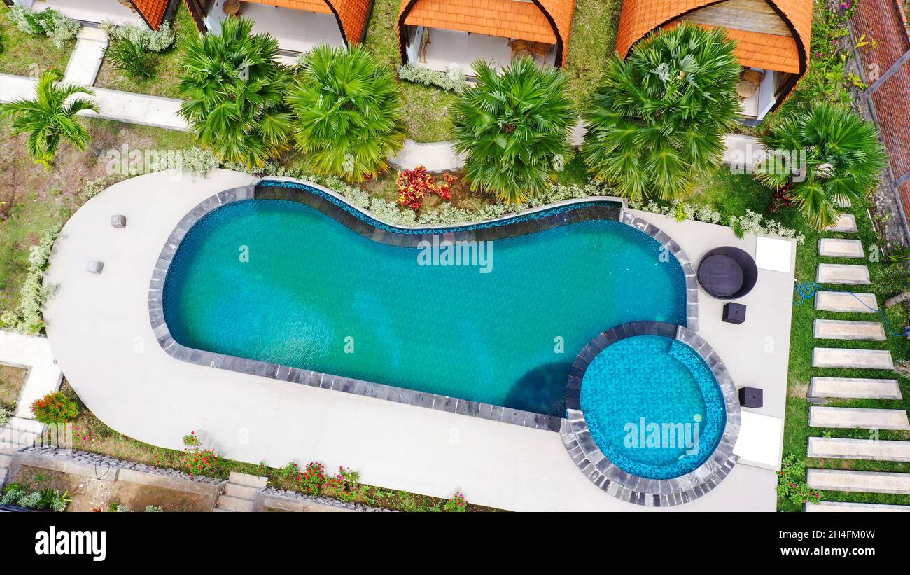 Aerial view of swimming pool in tropical garden in luxury hotel. The ...