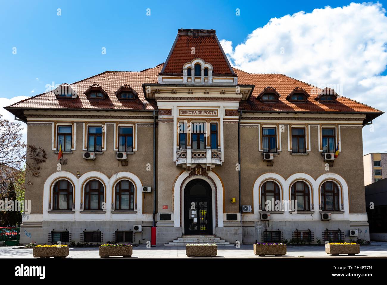 Bacau, Romania, May 02, 2021: Photo in front of the symmetrical Post Office building, which has 2 Romanian flags on the windows Stock Photo