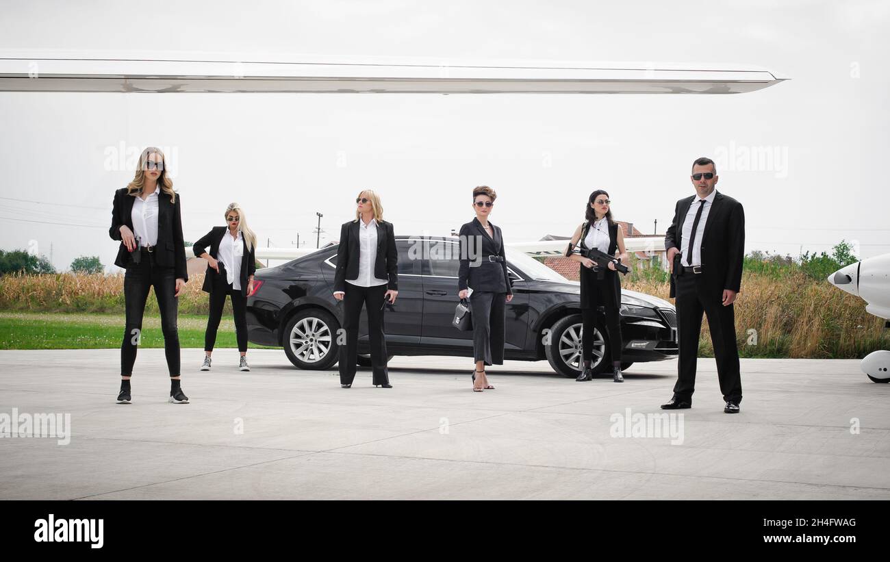 Professional team of female and male bodyguards protect famous VIP ...