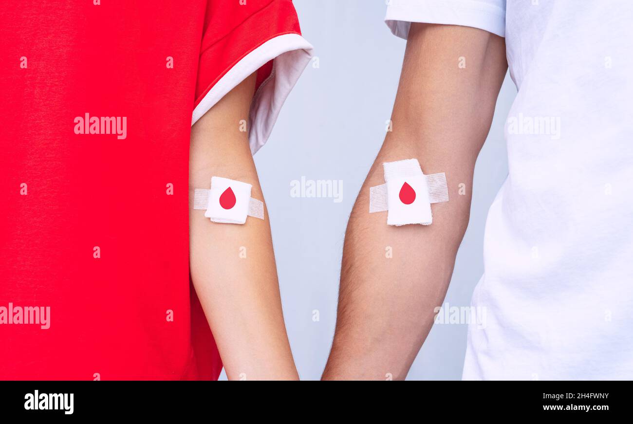 Giving blood saves lives. Blood donation. Man and woman blood donors with bandage Stock Photo