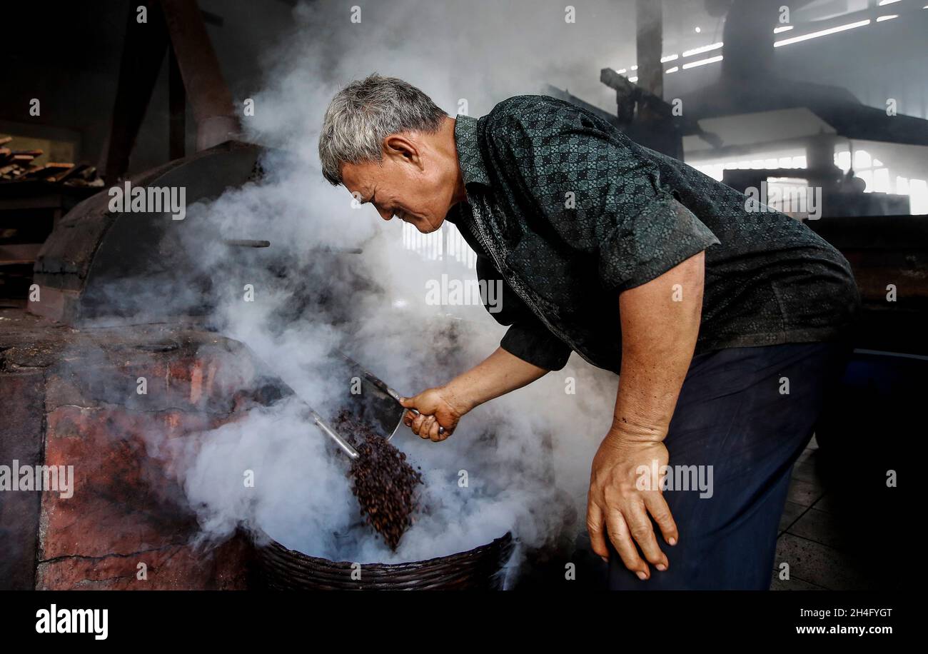 A worker seen collecting the fried coffee beans at Chuan Hoe coffee