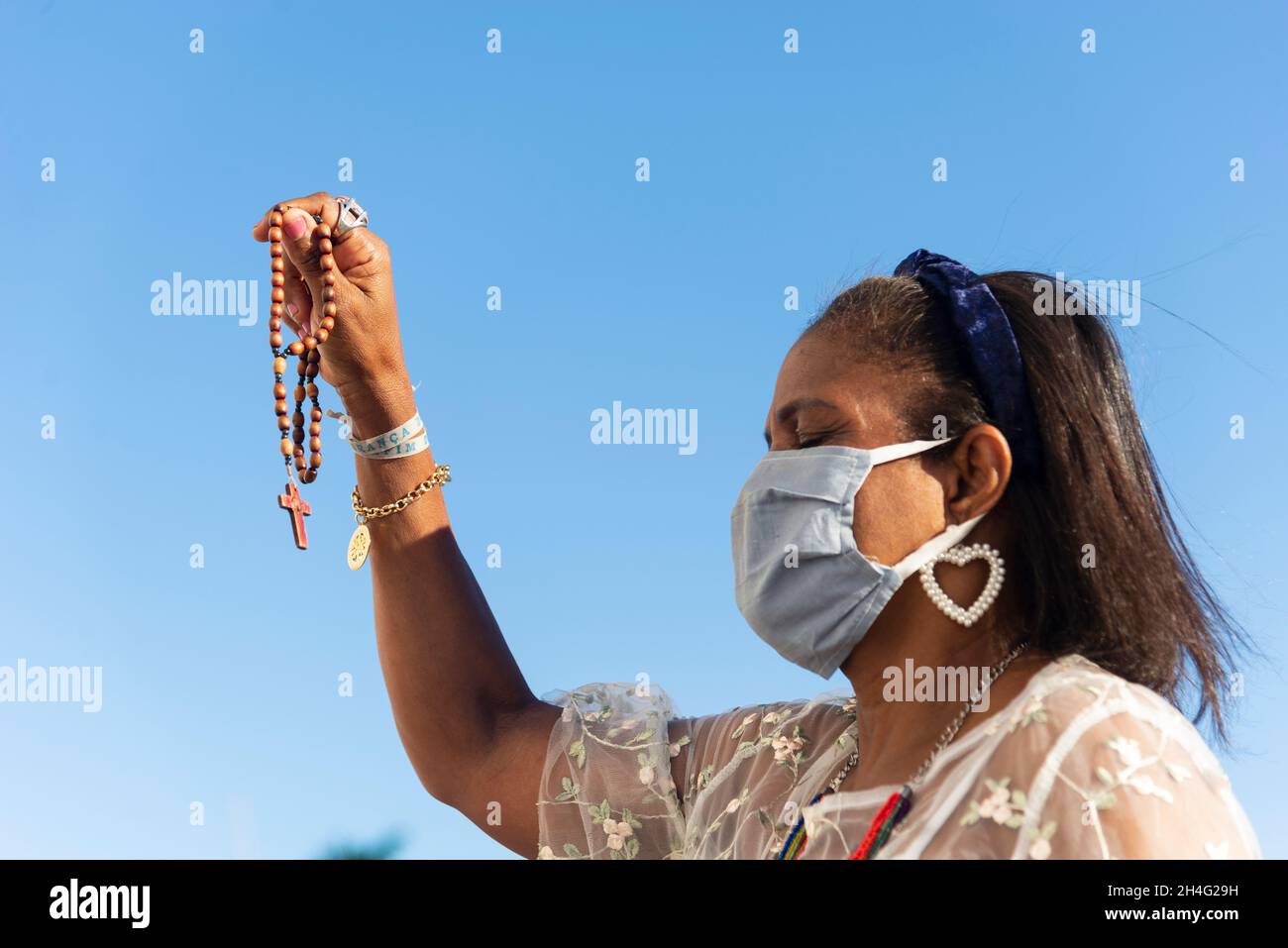 Salvador, Bahia, Brazil - January 01, 2021: Woman wearing face mask and praying at Senhor do Bonfim church in Salvador, Bahia, Brazil. Stock Photo