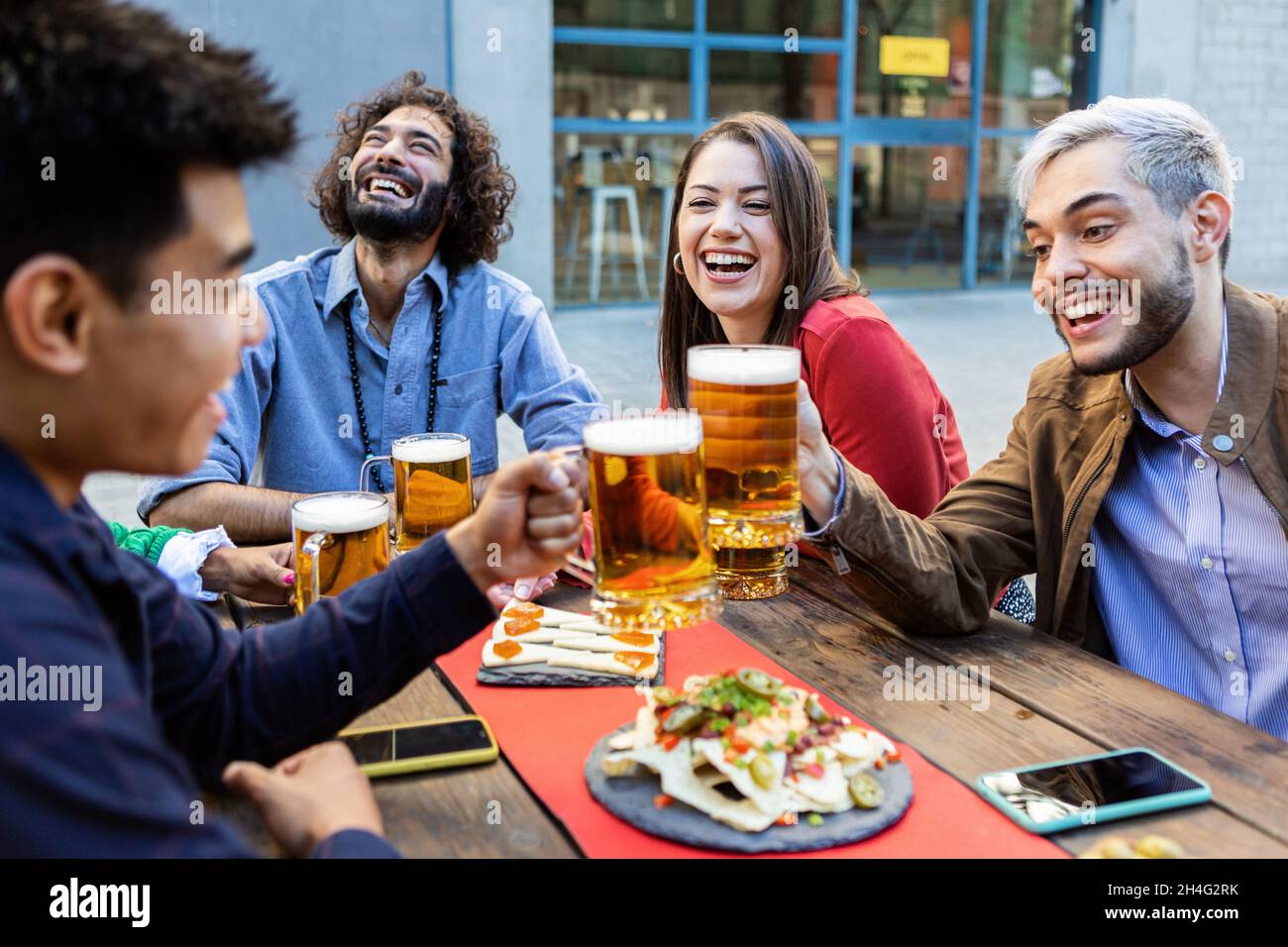 Group of hipster friends enjoying drink at bar terrace Stock Photo