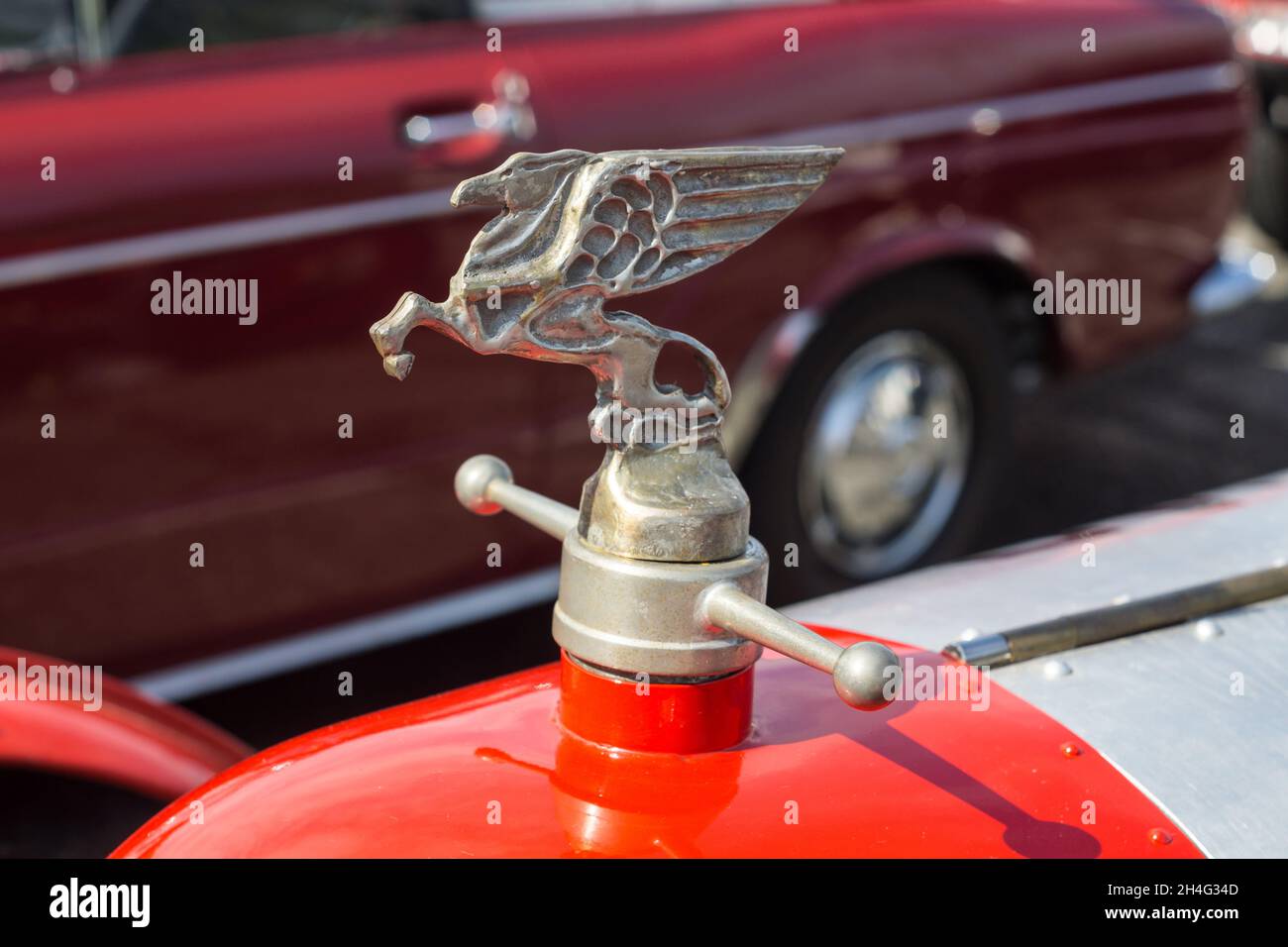 Close up detail of the hood bonnet ornament sculpture on a 1927 red Amilcar C6 Voiturette classic vintage sports racing car Stock Photo