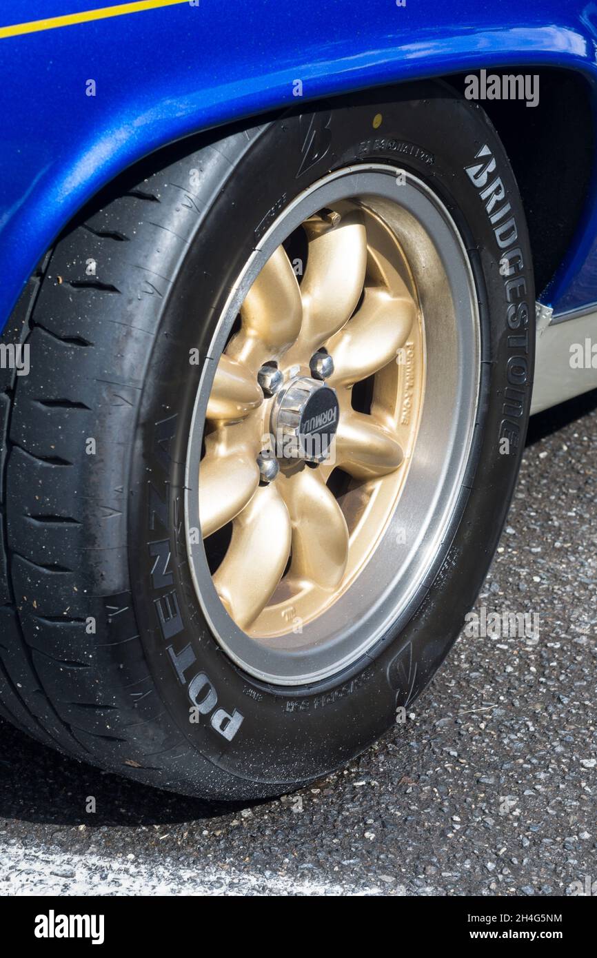 Close up detail of the gold minilite alloy wheels on a metallic blue