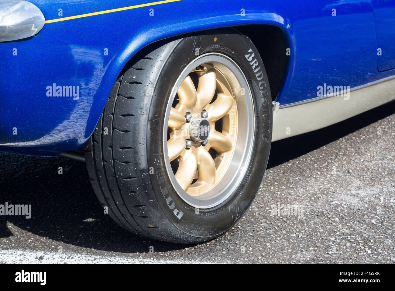 Close up detail of the gold minilite alloy wheels on a metallic blue