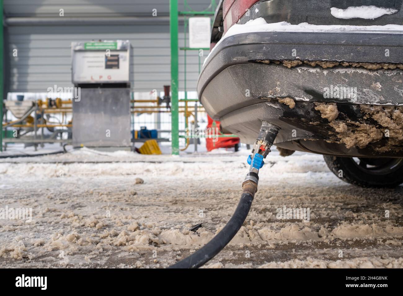Filling the car from the bottom of the bumper with gas in the winter at the gas station Stock