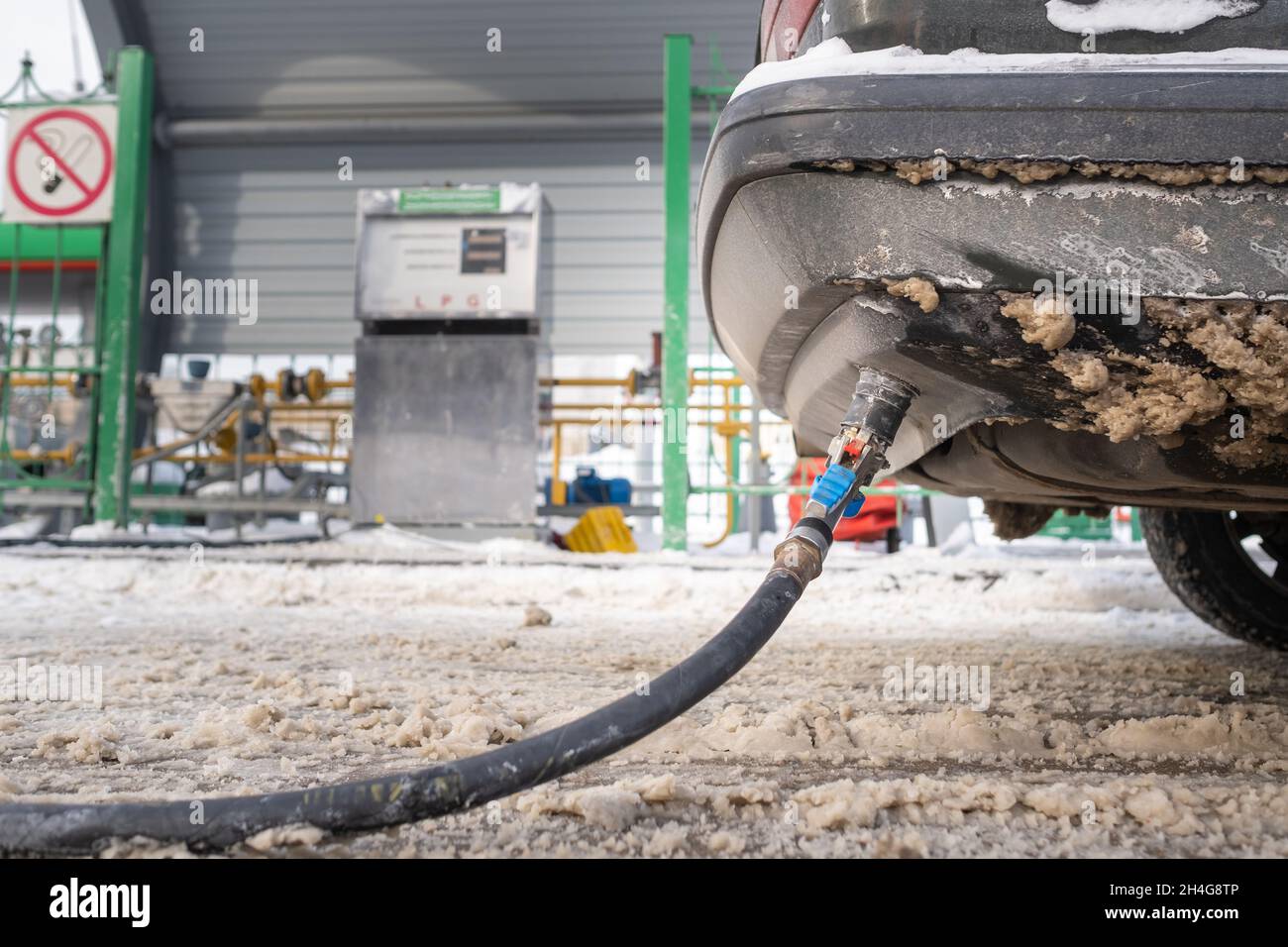 Filling the car from the bottom of the bumper with gas in the winter at the gas station Stock