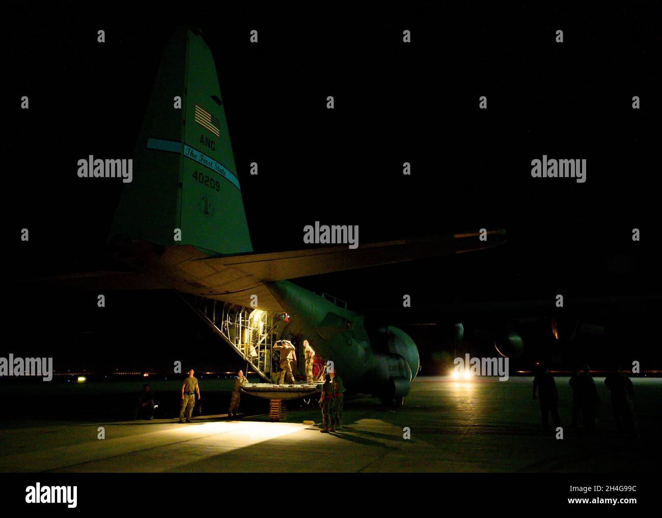 U.S. Air Force personnel load cargo onto a C-130 Hercules on the flightline at Prince Sultan Air Base, Kingdom of Saudi Arabia, prior to takeoff for Al Udeid Air Base, Qatar, Aug. 21, 2021. The 378th Air Expeditionary Wing provided air support, logistics, manpower and resources to U.S. Air Forces Central command in support of the evacuation of American citizens, special immigrant visa applicants and other at-risk individuals from Afghanistan. (U.S. Air Force photo by Senior Airman Samuel Earick) Stock Photo