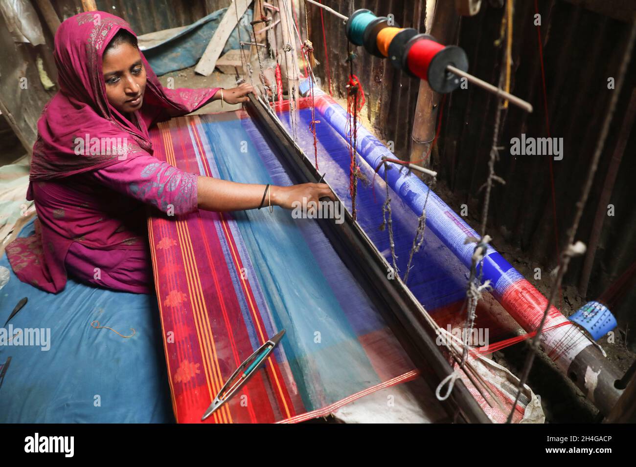 Dhaka, Bangladesh. 02nd Nov, 2021. Rina Begum seen making Jamdani saree at Demra Jamdani Palli. Jamdani is one of the finest muslin textiels of Bengal, produced in Dhaka District, Bangladesh for centuries. The Historic production of jamdani was patronized by imperial warrants of the Mughal emperors. Under British colonialism, the Bengali Jamdani and muslin industries rapidly declined due to colonial import policies favoring industrially manufactured textiles. Credit: SOPA Images Limited/Alamy Live News Stock Photo