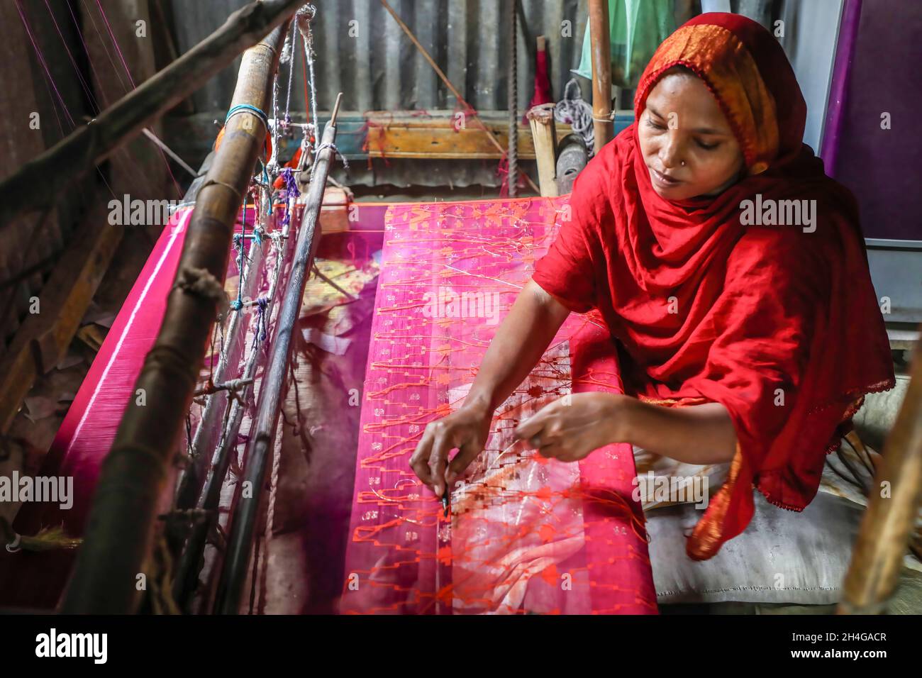 Dhaka, Bangladesh. 02nd Nov, 2021. A women seen making Jamdani saree at Demra Jamdani Palli. Jamdani is one of the finest muslin textiels of Bengal, produced in Dhaka District, Bangladesh for centuries. The Historic production of jamdani was patronized by imperial warrants of the Mughal emperors. Under British colonialism, the Bengali Jamdani and muslin industries rapidly declined due to colonial import policies favoring industrially manufactured textiles. Credit: SOPA Images Limited/Alamy Live News Stock Photo