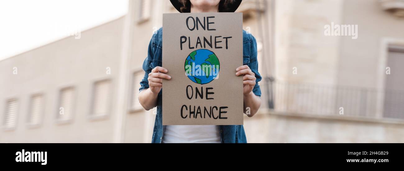 Young activist marching and protest for climate change holding banner - Demonstration for Ecology and environment concept Stock Photo