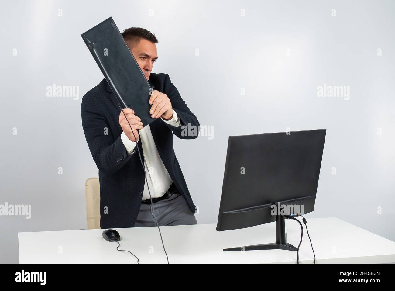 Angry man is destroying a keyboard Stock Photo Alamy