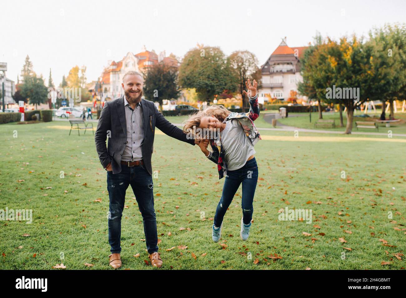 Father and daughter running on the grass in the old town of Austria.A family walks through a small town in Austria.Europe.Felden am Werten see. Stock Photo