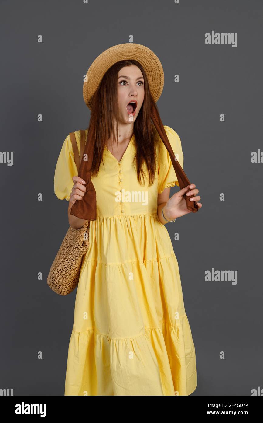 Shocked woman in yellow dress standing in studio Stock Photo - Alamy