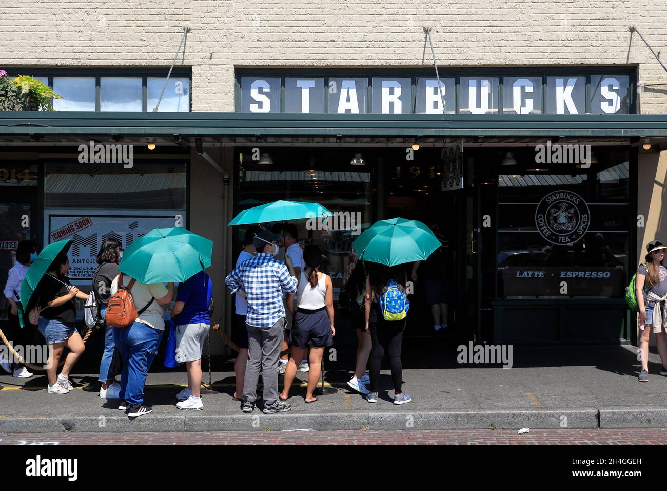 Customers carrying green umbrellas provided by Starbucks coffee shop