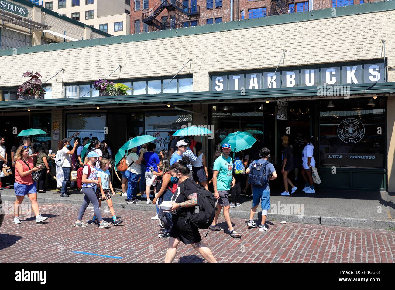 Customers carrying green umbrellas provided by Starbucks coffee shop