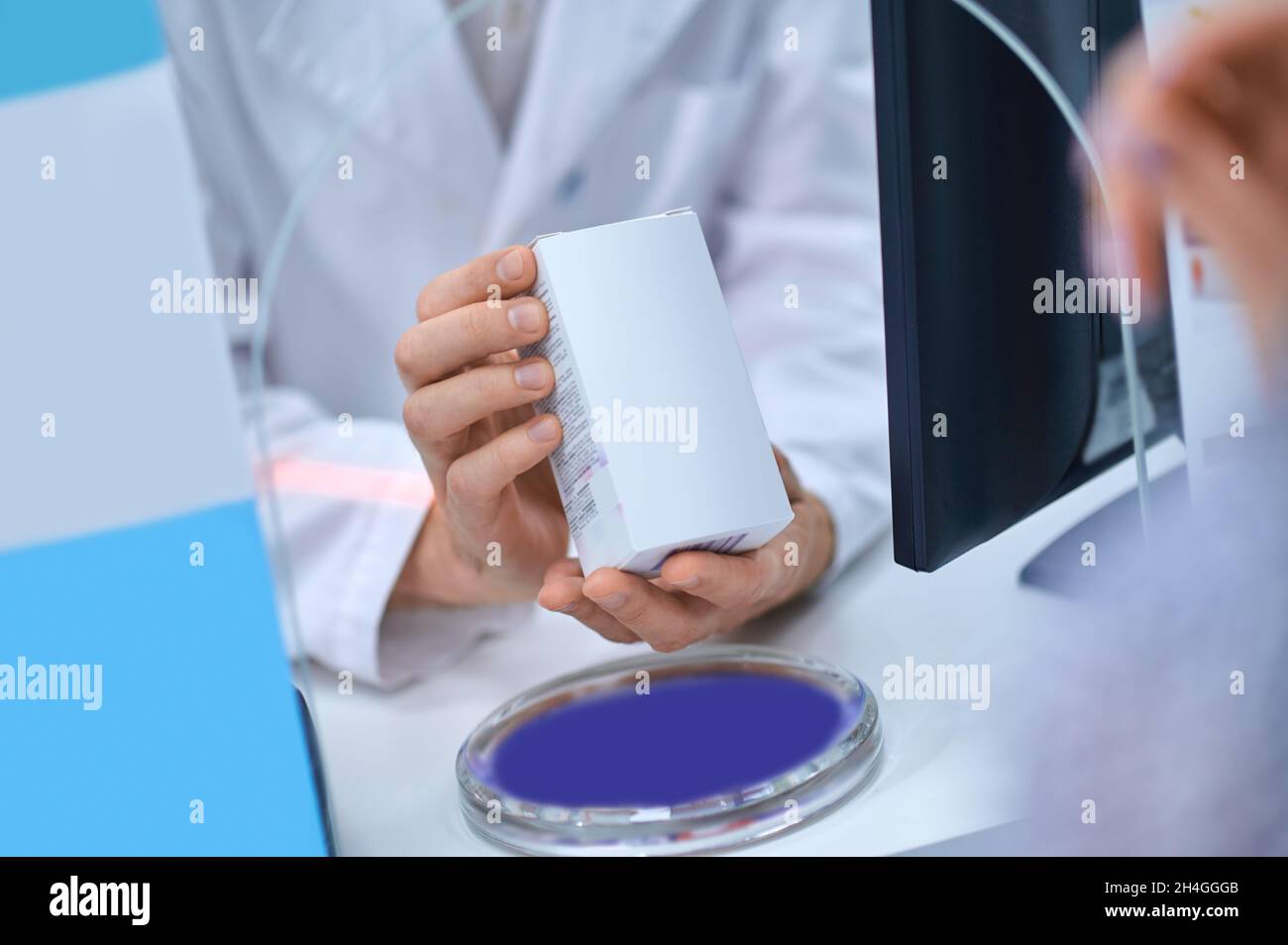 Pharmacy worker hands showing medicine packaging Stock Photo