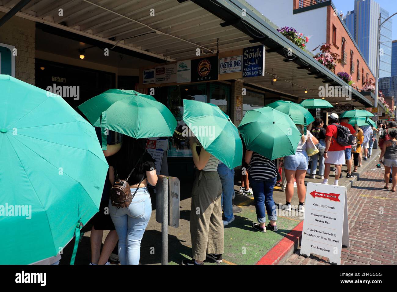 Customers carrying green umbrellas provided by Starbucks coffee shop