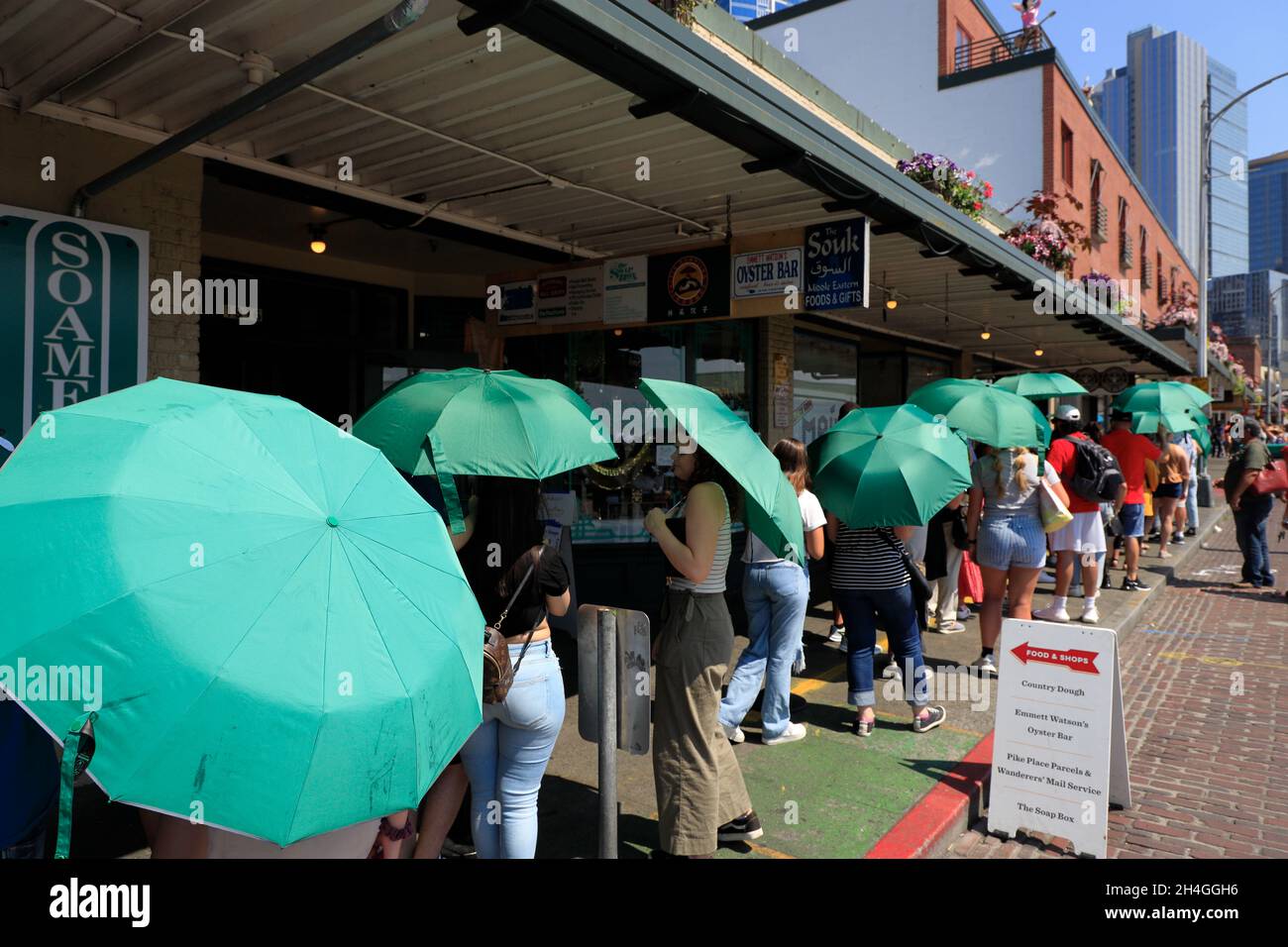 Customers carrying green umbrellas provided by Starbucks coffee shop