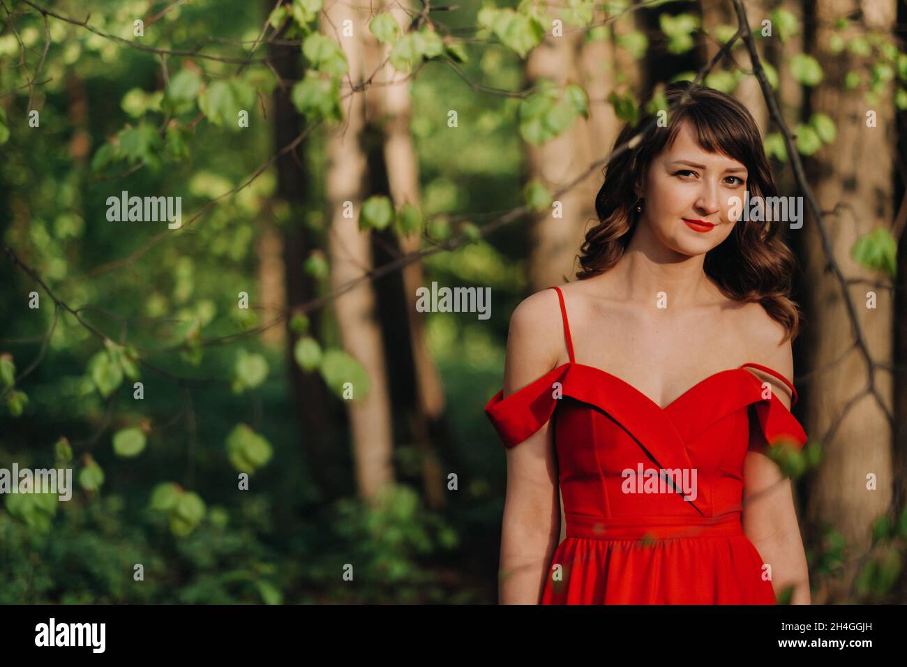 Spring Portrait of a laughing girl in a long red dress with long hair ...