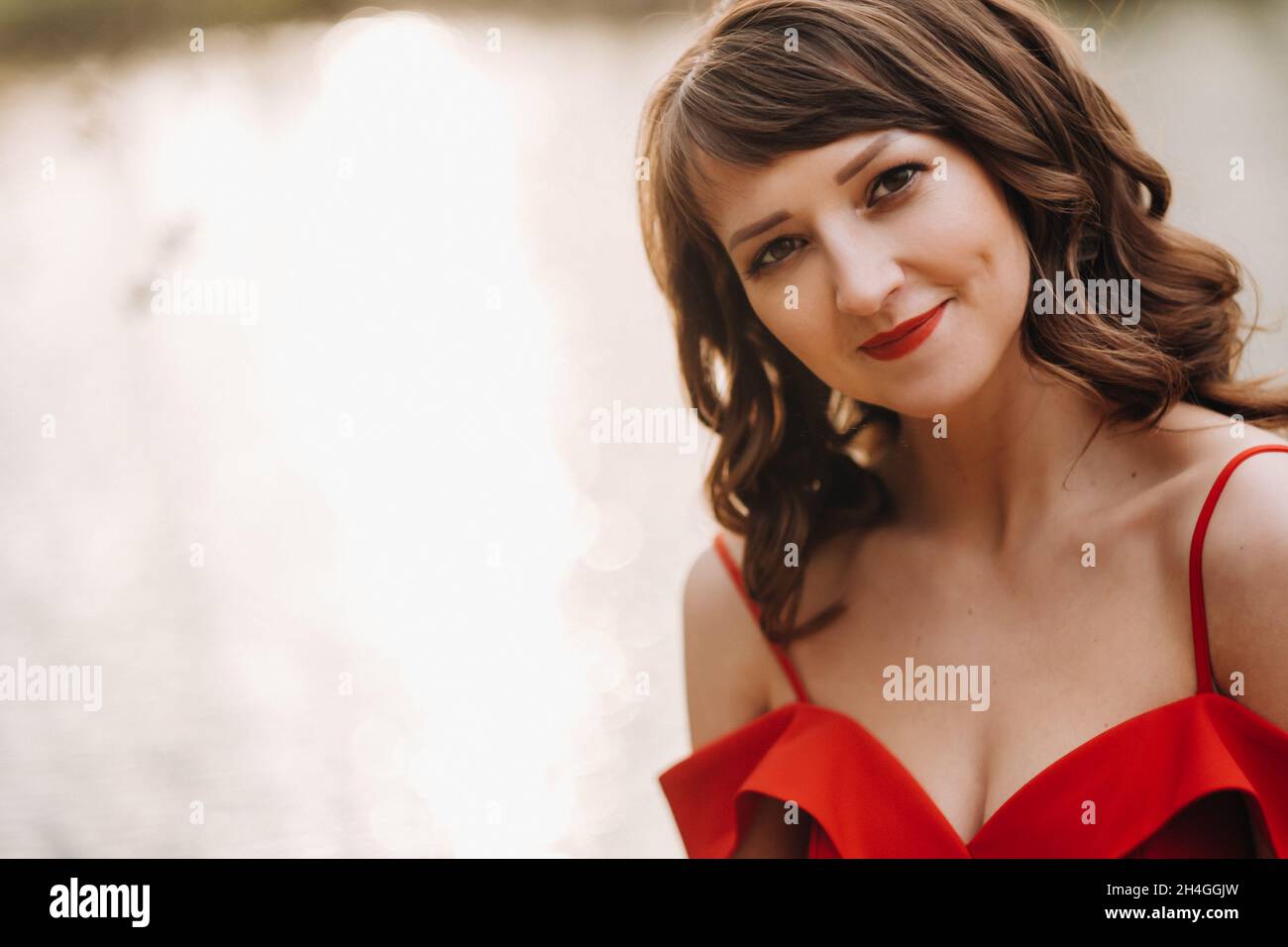 Spring Portrait of a laughing girl in a long red dress with long hair ...